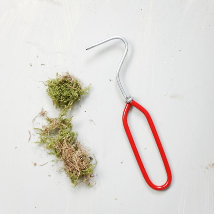 Action shot of the speedweeder weeding tool with some moss on the side