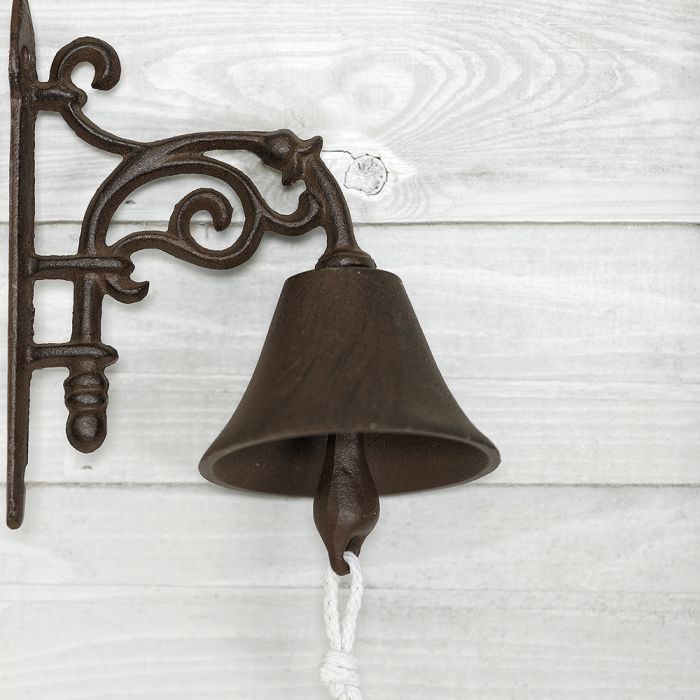Detailed view of our traditional cast iron doorbell, hanging in a scroll detailed wall bracket