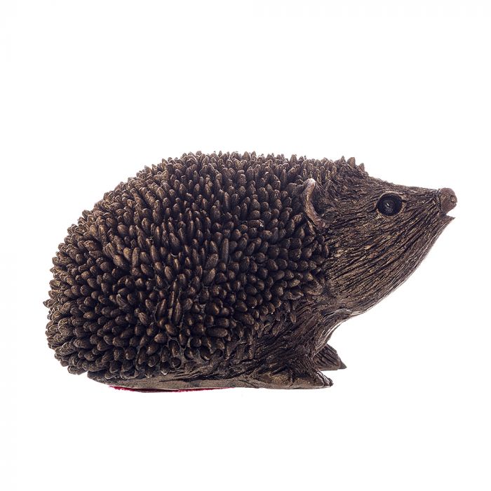 Side profile of a small bronze finish resin hedgehog, looking to the right and with a raised snout