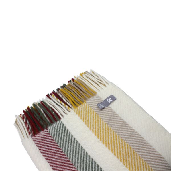 Close up of the Vintage Fishbone Stripe throw folded up, with multicolour tassels on the top side.