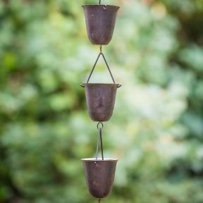 Close up of rain chain showing detail of three of the small buckets.