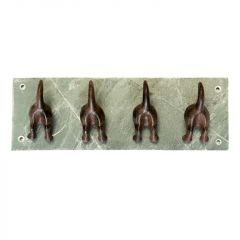 A slate back piece with 4 cast iron dog tails and feet forming coat hooks