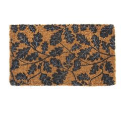 A sturdy rectangular door mat made from natural coir fibres decorated with a trailing oakleaf pattern in black and grey