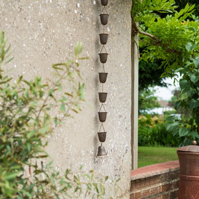 Rain chain hanging outside on a garden wall to show product in situ.