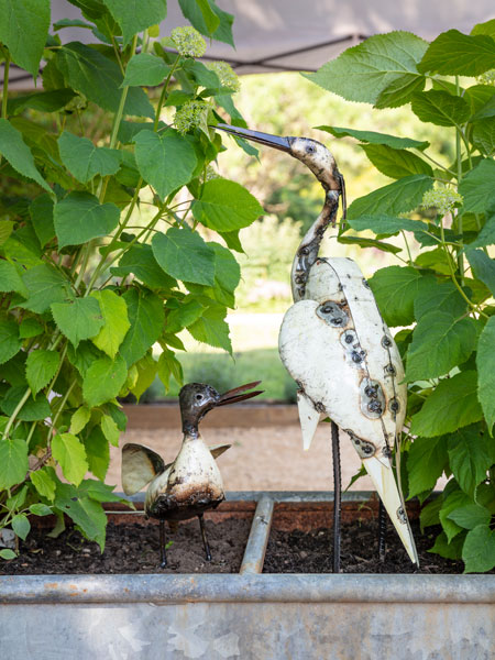 Browse the National Trust garden decor range for great gift ideas, garden accessories and essentials. Image shows White Egret Metal Sculpture and White Duck Metal Sculpture in planter, surrounded by green foliage. Get ahead and prepare your garden for spring with garden decor from the National Trust online shop, every purchase helps look after the places in our care. 