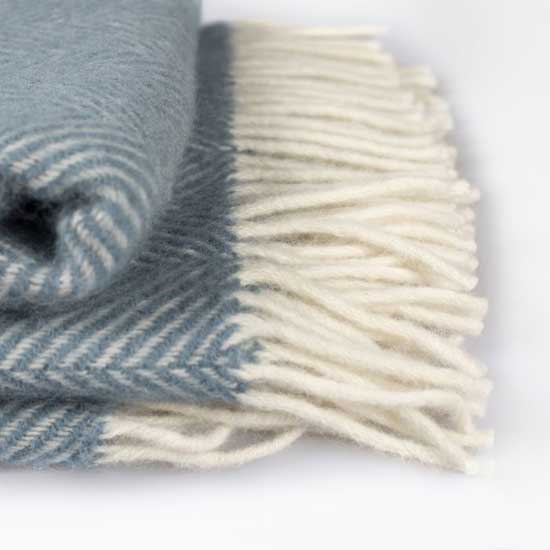 National Trust Wool Throw, Petrol Blue. Image shows close up of herringbone weave and cream tassels on Petrol Blue throw. Browse the National Trust blanket and throws range for winter warmers to see you through the chilly season.