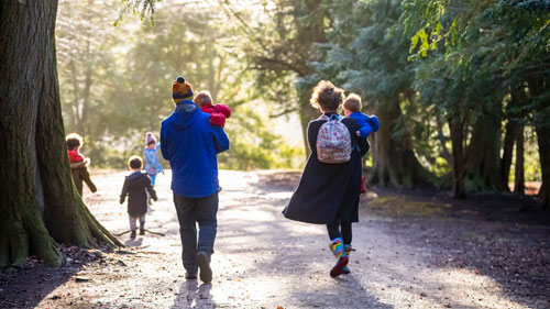 Give someone special the gift of National Trust membership - browse our membership types, from family to adult, young person and senior. Image shows group including adults and children walking through the parkland at Fountains Abbey during winter.