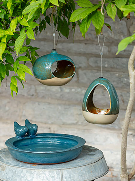 Birds & wildlife. Image shows Petrol Blue Bird Bath sat atop garden table, with CJ Wildlife Water Drinker and Feeder hanging from tree above.