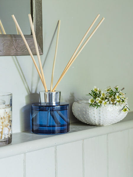 Home decor & accessories. Image shows Bergamot and Seamoss Reed Diffuser, with blue glass carrier and FSC reeds, sat discreetly in bathroom with Sea Urchin trinket dish by its side.