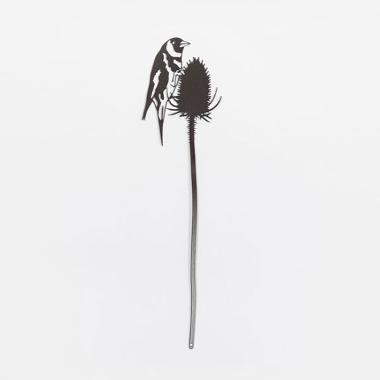 Pot Stem - Goldfinch £13.00, from the National Trust's new garden decor range. Image shows steel pot stem, with powder coated grey finish, on a plain grey background. Topped with the silhouette of a goldfinch, this pot stem can be used indoors or out. Every purchase from one of our shops helps look after the places in National Trust care.