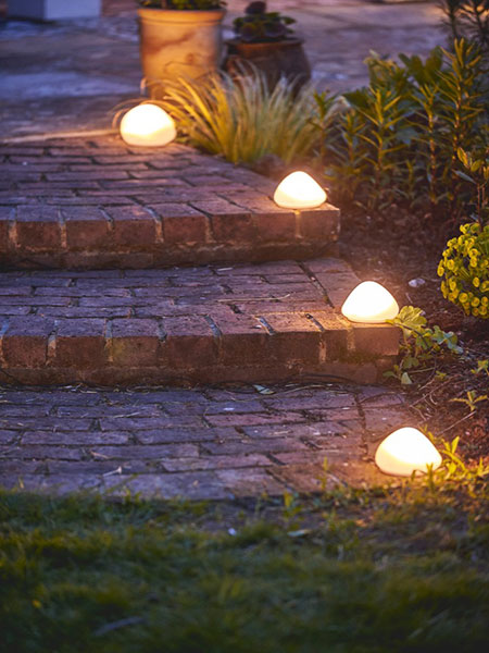 Outdoor living. Image shows several of the Solar Pebble on garden steps, lighting the way down to the garden. 