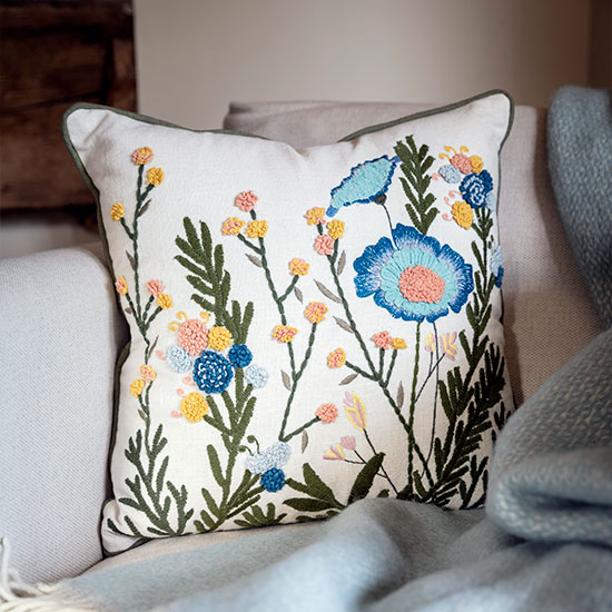 National Trust Embroidered Cushion - Garden - image shows square cushion with removable cover on an armchair, with the Illusion Wool Throw in Duck Egg to create a cosy corner.