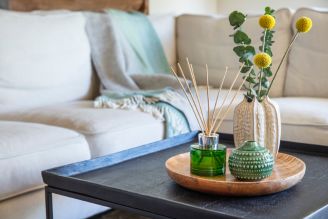 Home fragrance - image shows the Coffee and Bergamot Reed Diffuser on a windowsill, with a soft light shining through the window and illuminating the retro, vintage inspired glass bottle.