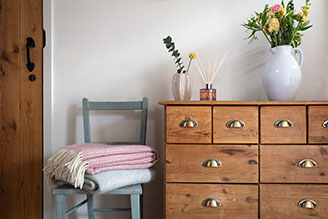 Throws & blankets - image shows the Jacquard Leaves Throw paired with the Illusion Red Throw on a windowsill, with pampas grass adding a natural touch to the home decor.